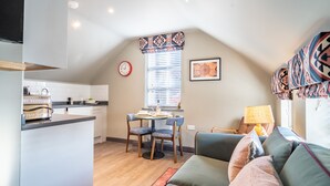 Una sala acogedora con un sofá y un comedor con sillas y una mesa.