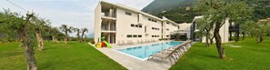 Ein modernes Hotel mit Schwimmbad, Außenbereich und Blick auf die Berge.