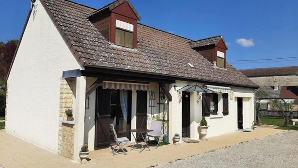 A single-story house with a sloped roof, a covered porch with outdoor seating, and a satellite dish on the roof. - La Poulette (Ancy-le-Libre)