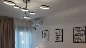 A modern bedroom with a bed, bedside tables, and a ceiling light fixture. - GTD35501 - Unique Villa in Voula Riviera (Vari-Voula-Vouliagmeni)