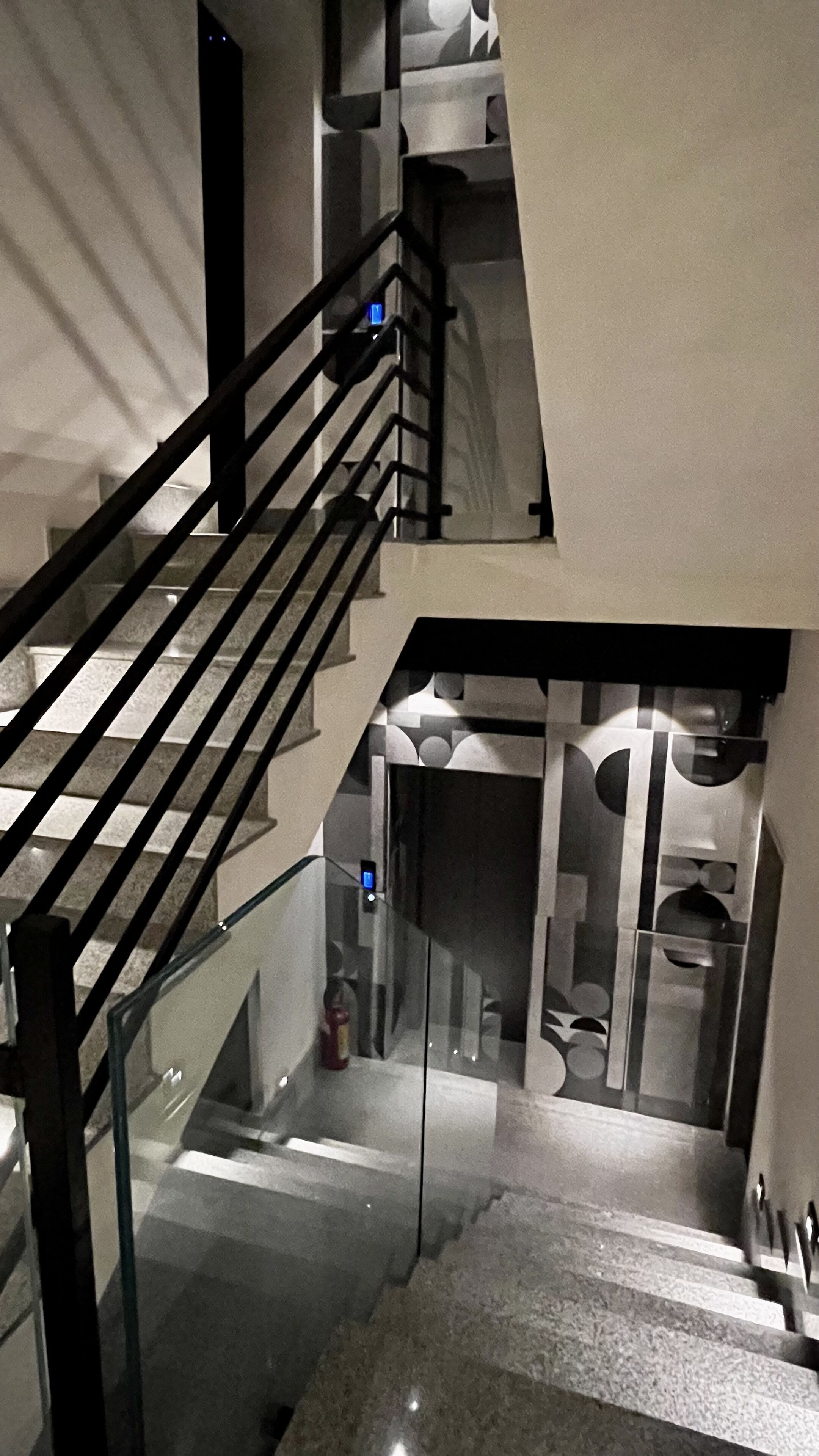 A multi-level interior with a staircase, glass railings, and a modern design.