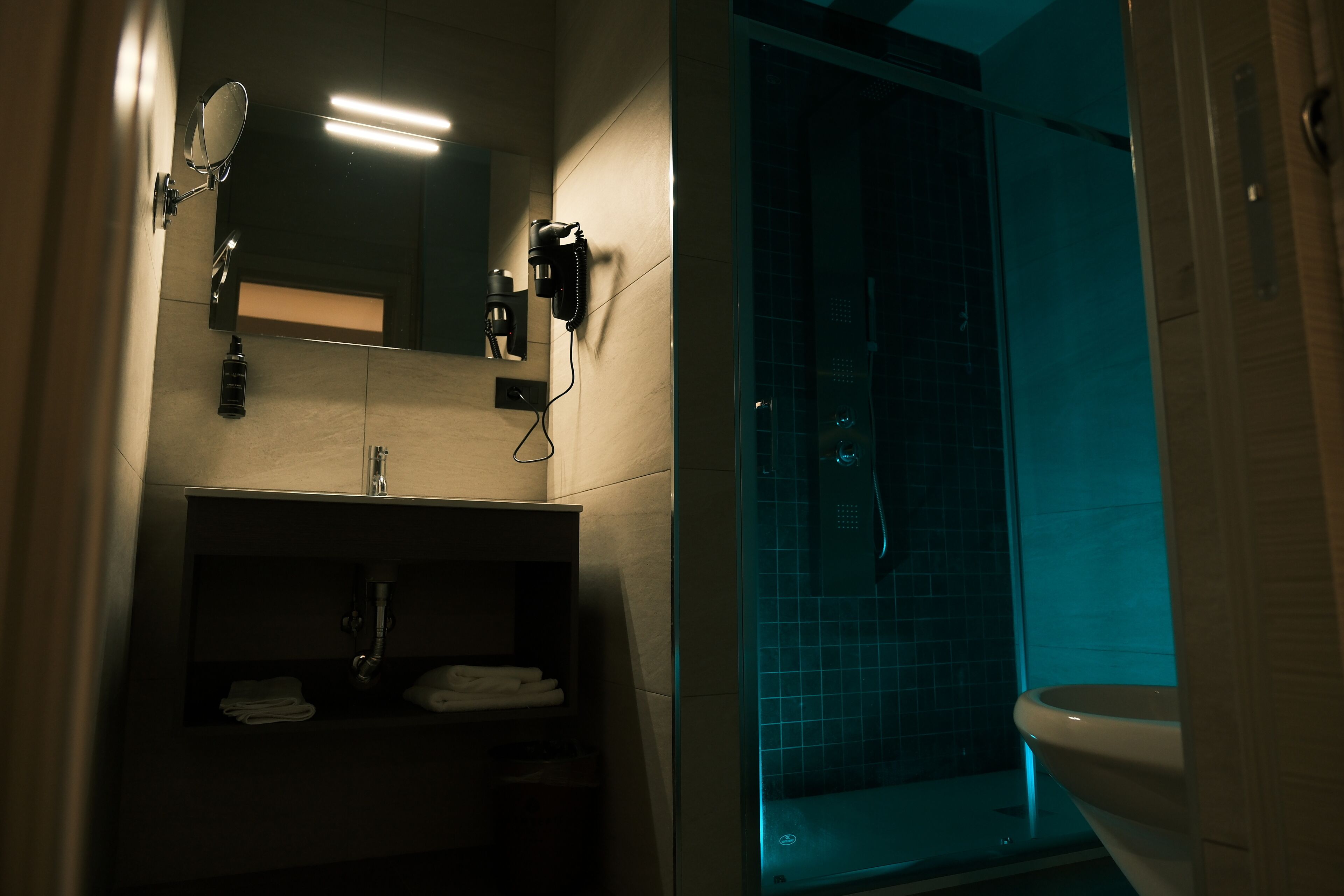 A modern bathroom with a glass-enclosed shower, a vanity with a mirror, and a toilet.