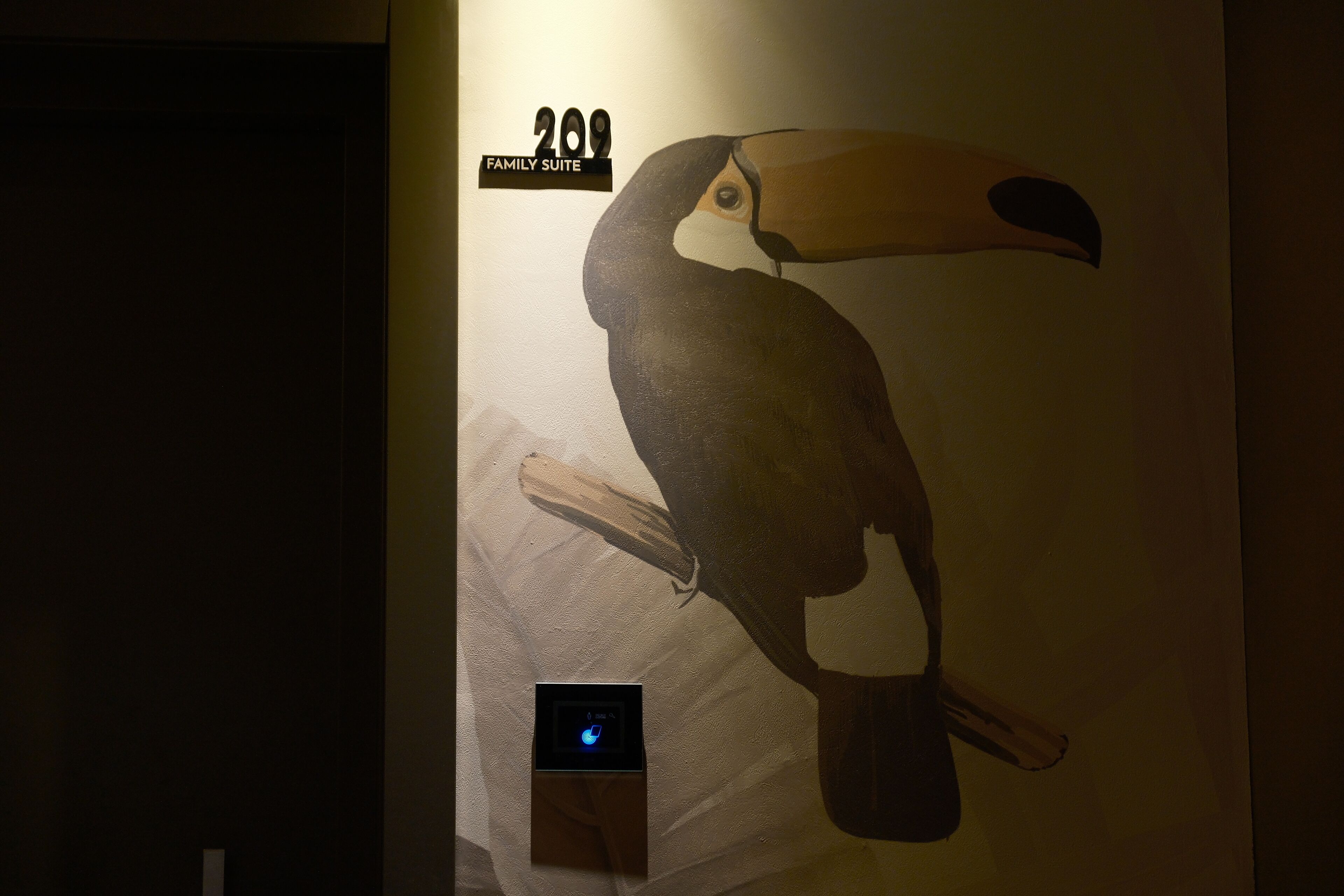 Un muro con un'illustrazione di un tucano e un display digitale.