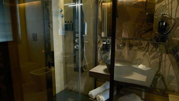 Une salle de bain moderne avec une douche à parois de verre, un meuble-lavabo avec un miroir et un porte-serviettes.