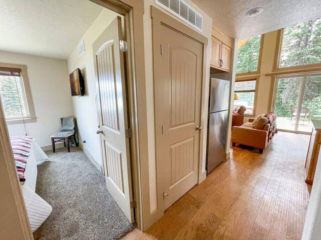 A compact living space with a kitchenette, a dining area, and a bedroom.