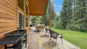 A wooden cabin with a deck, outdoor furniture, and a grill. - Private Cabin at the Foot of the Mountains (Donnelly)