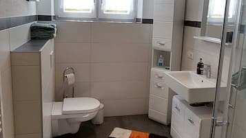 Een douche, een haardroger, handdoeken, toiletpapier