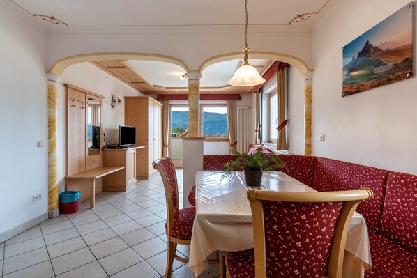 Comedor con una mesa, sillas y vistas a las montañas.