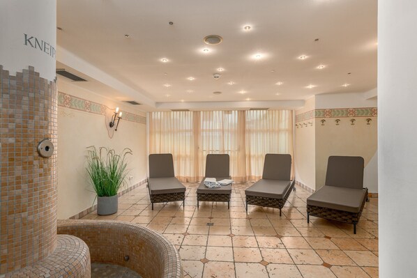 A lounge area with four cushioned chairs, a small table, and a potted plant.