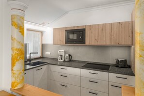 Cafetera o tetera, frigorífico, microondas y placa de cocina
