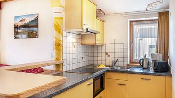 Een koelkast, een magnetron, een kookplaat, een vaatwasser