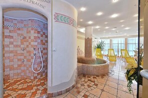 A spa area with a mosaic-tiled shower, a hot tub, and yellow chairs. - 'Residence Diana Apartment 203' with Mountain View, Balcony & Wi-Fi (Terenten)