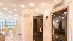Un área de spa con una puerta de vidrio que dice 'Finische Sauna', sillas amarillas y un piso estampado.