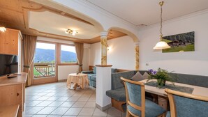 Ein Essbereich mit Tisch, Stühlen und Blick durch ein Fenster.