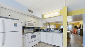A modern kitchen with white cabinets, a microwave, an oven, and a dishwasher. - Located right on the beachfront, this bright, cheerful and beautiful well-appointed Villa. (St. George Island)