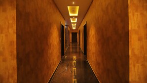 Um corredor comprido e estreito, com paredes de madeira e piso lustroso, que leva a um fim escuro.