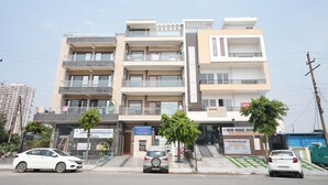 Un edificio de varios pisos con balcones, una clínica y una clínica de dermatología en la planta baja.