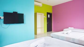Habitación de hotel con dos camas, un televisor y una puerta que da a un baño.
