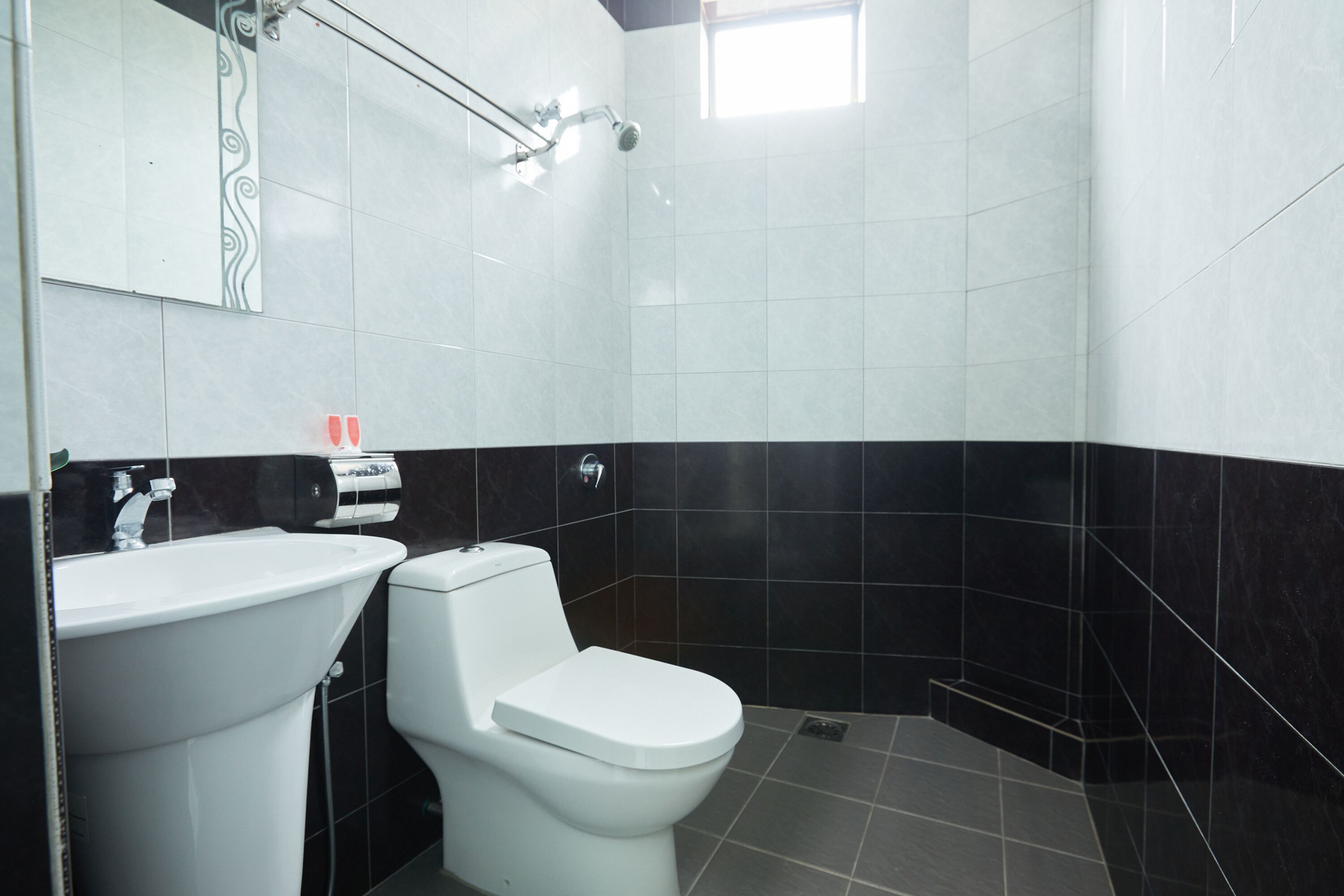 A bathroom with a white sink, a toilet, and a shower area.