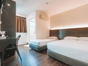 Habitación de hotel con dos camas individuales, un escritorio con silla, un armario y un equipo de aire acondicionado.