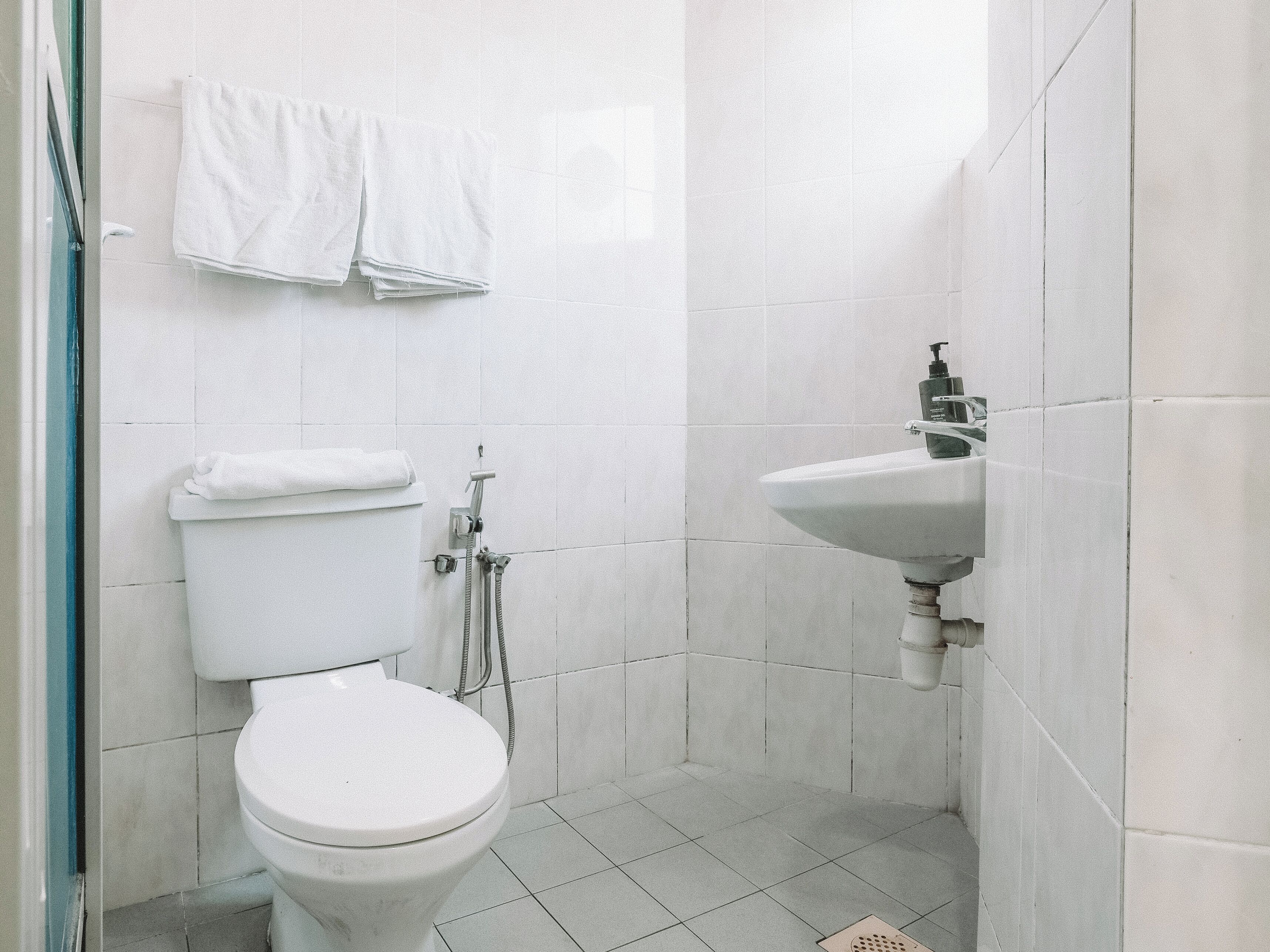 A bathroom with a toilet, a shower, and a sink.