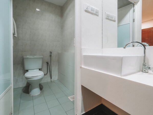 Un baño con inodoro, ducha y lavabo.