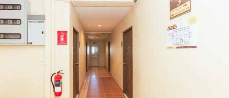Un pasillo con un extintor, un cartel que indica el piso 3 y una señal de salida de incendios.