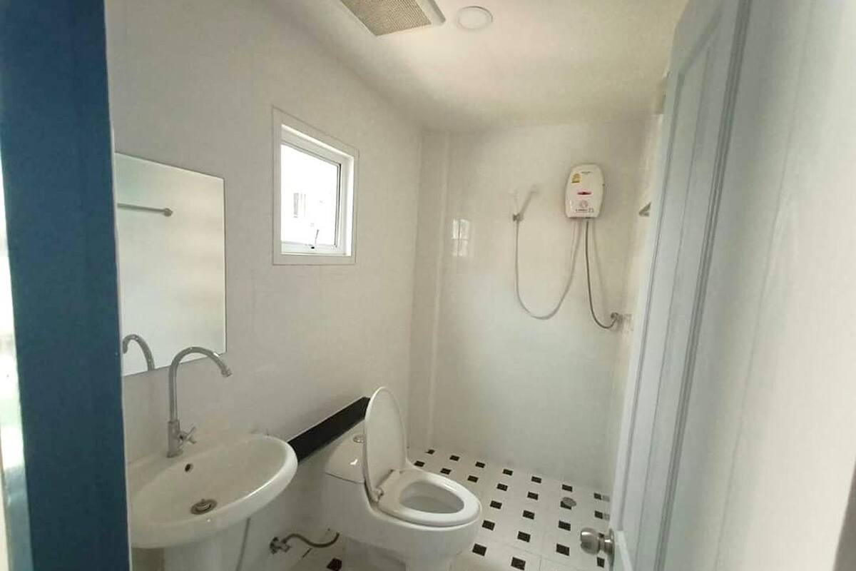 A small bathroom with a toilet, sink, and shower.