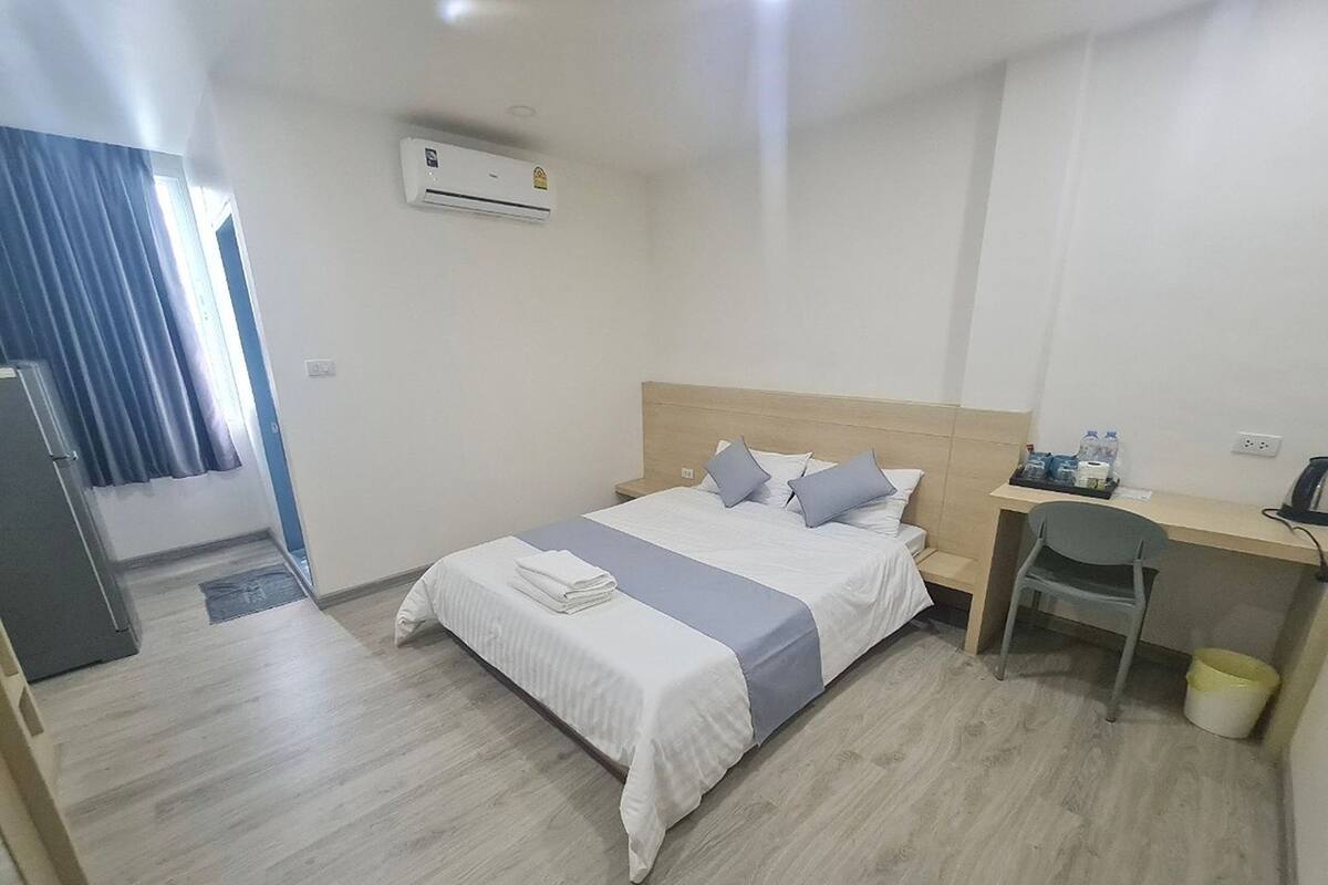 A hotel room with a bed, a desk, and a chair.