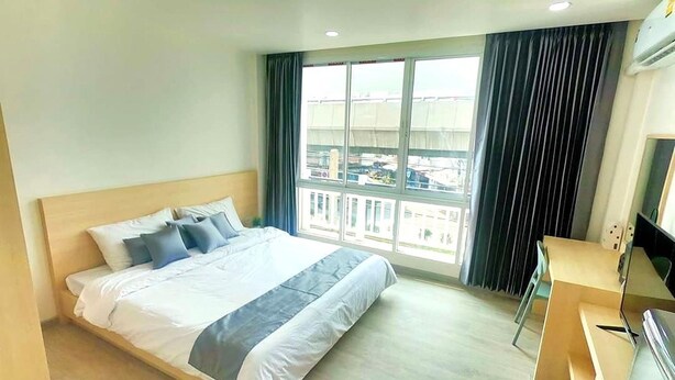 Ein Hotelzimmer mit einem großen Bett, einem Schreibtisch und einem Fenster mit Vorhängen.