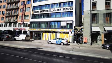 A building with a sign for 'Design & Kunsthotel OKM München' featuring a modern facade and large windows.
