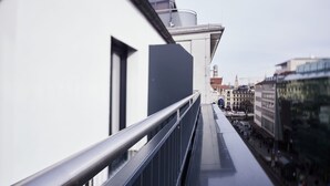 A modern building with a balcony overlooking a city street. - Design- und Kunsthotel München (Munich)