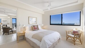 Ein Schlafzimmer mit großem Bett, Meerblick, Essbereich und Küche.