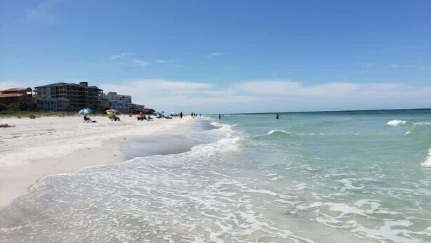 Una playa con un edificio al fondo.