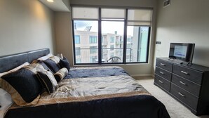 Um quarto com uma cama grande, uma cômoda e uma televisão.