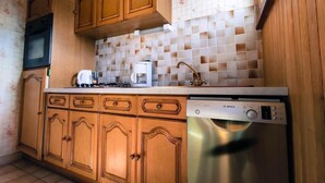 A kitchen with wooden cabinets, a Bosch dishwasher, and a tiled backsplash.