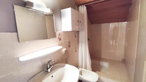 A bathroom with a sink, toilet, and shower curtain.