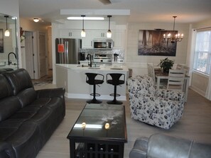 Relax in this stylish living room with a sleek sofa, glass coffee table, and a large mirror above.