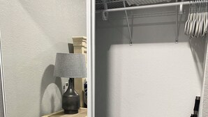 A walk-in closet with a mirror, a lamp, and a storage unit.
