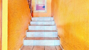 Una escalera de piedra con peldaños que conducen a una puerta con un panel de vidrio.