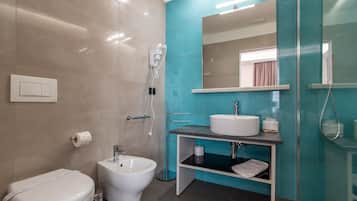 A modern bathroom with a bidet, a toilet, a sink, and a mirror.