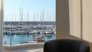 A modern room with a large window overlooking a marina.