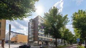 Un edificio moderno con techo plano, ventanas grandes y un paso de peatones.