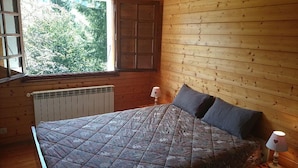 A wooden room with a bed, a window, and a radiator. - Wifi, Ground floor, view mountain, terrace, tv, ski locker, 94m², Le Grand Bornand (Le Grand-Bornand)