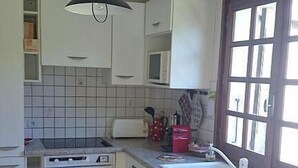 A kitchen with white cabinets, a tiled backsplash, a stove, a sink, and a window with curtains. - Wifi, Ground floor, view mountain, terrace, tv, ski locker, 94m², Le Grand Bornand (Le Grand-Bornand)