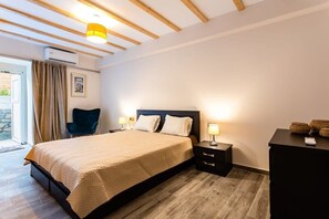 A bedroom with a bed, bedside tables, a chair, and a desk.