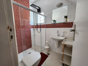 A bathroom with a glass-enclosed shower, a white sink, and a toilet. - AP Pepê Jacuzzi/solário (Rio de Janeiro)