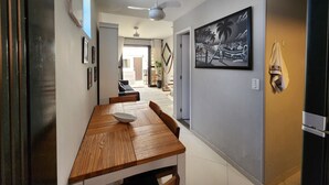 Eine moderne Küche mit einem Holzespeisetisch, einem Deckenventilator und einem Schwarz-Weiß-Gemälde an der Wand.