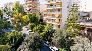 A multi-story residential building with balconies, parked cars, and surrounding trees. - GTD31504 - Art room of Athens - Luna (Palaio Faliro)