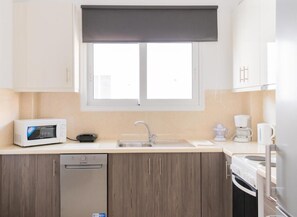 A modern kitchen with a built-in microwave, dishwasher, and a double sink.